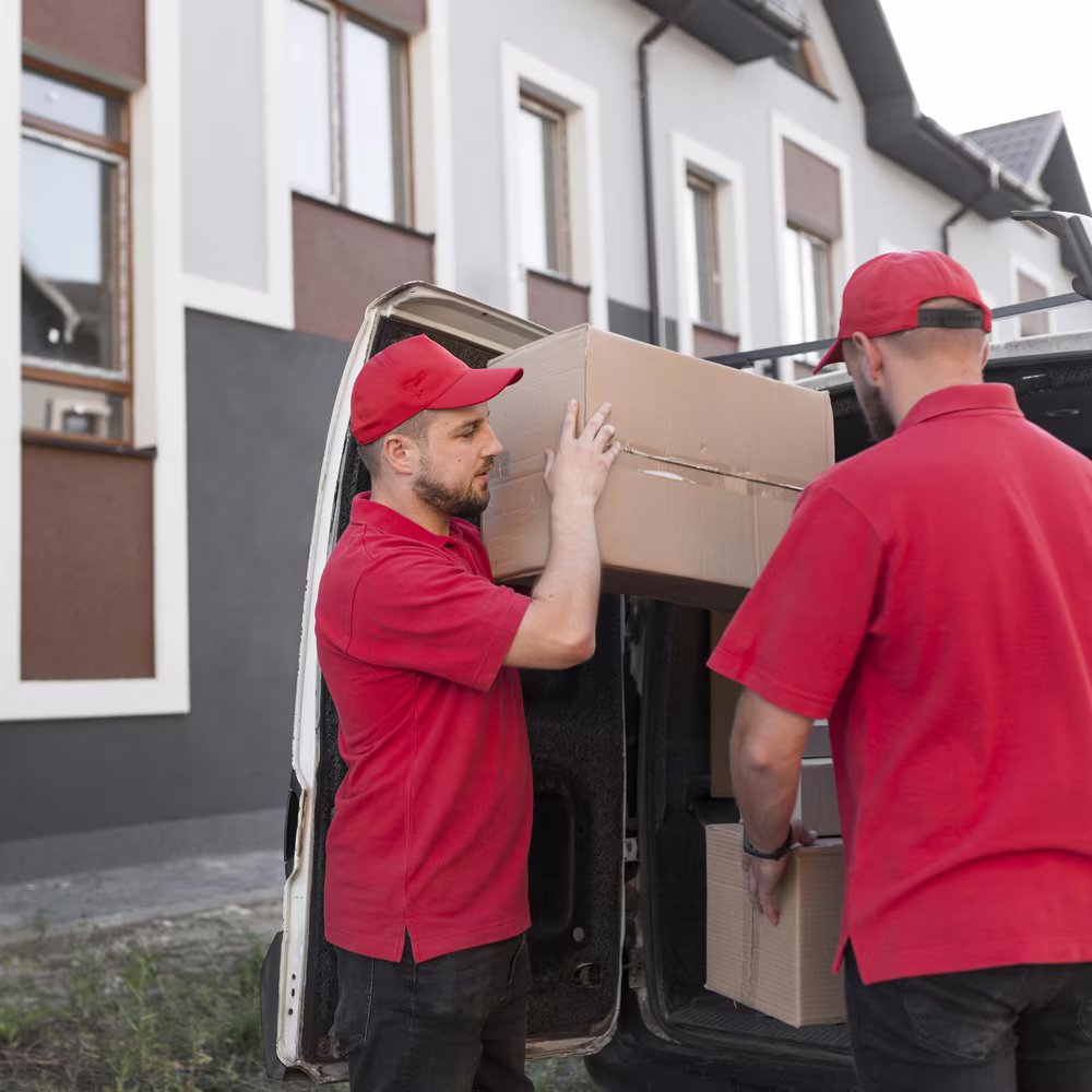 Entrümpelung Berlin: Arbeiter laden Kartons in den Transporter